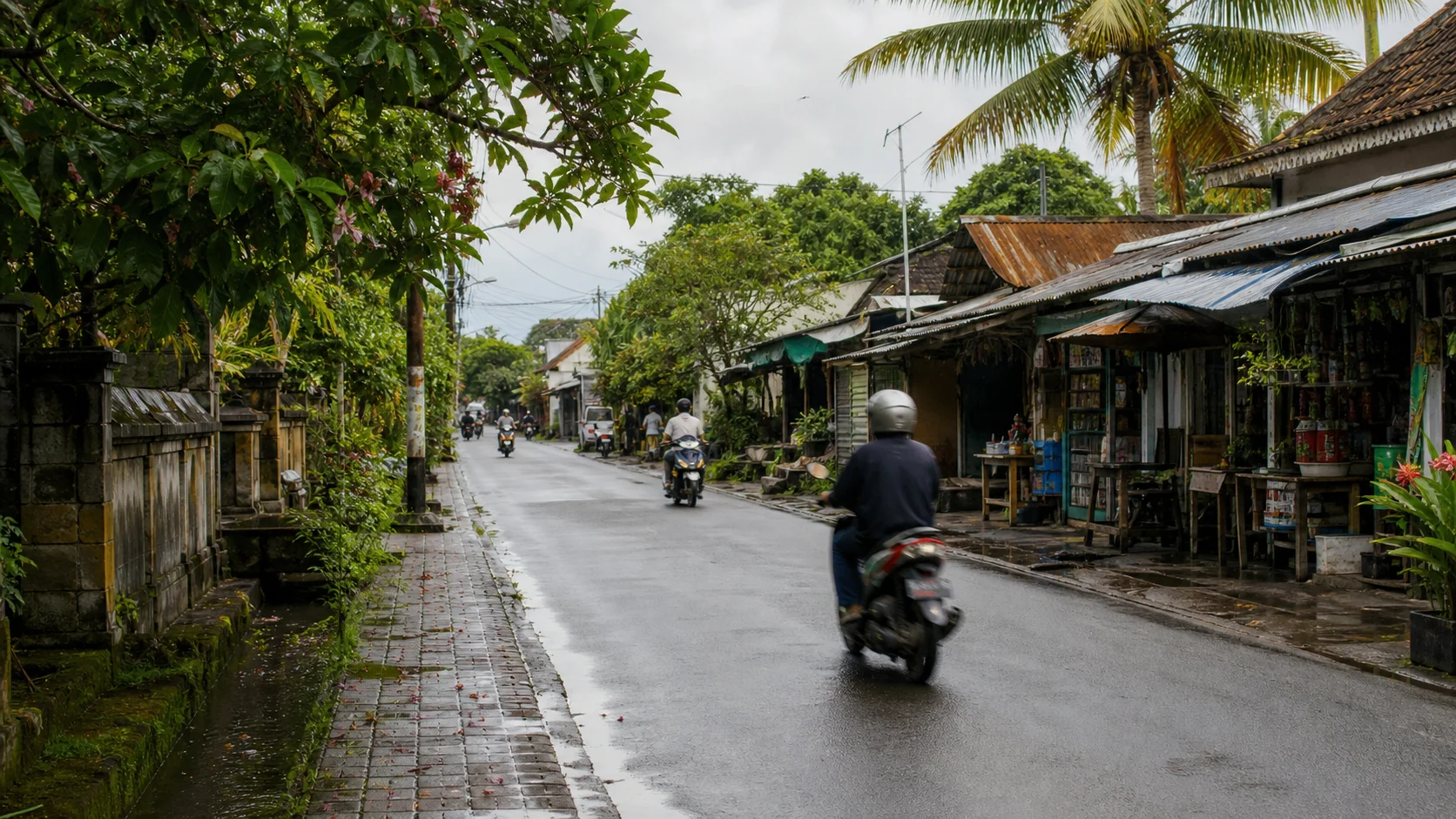 Ordinary Bali road linking homes, shops and scooters after tropical rain