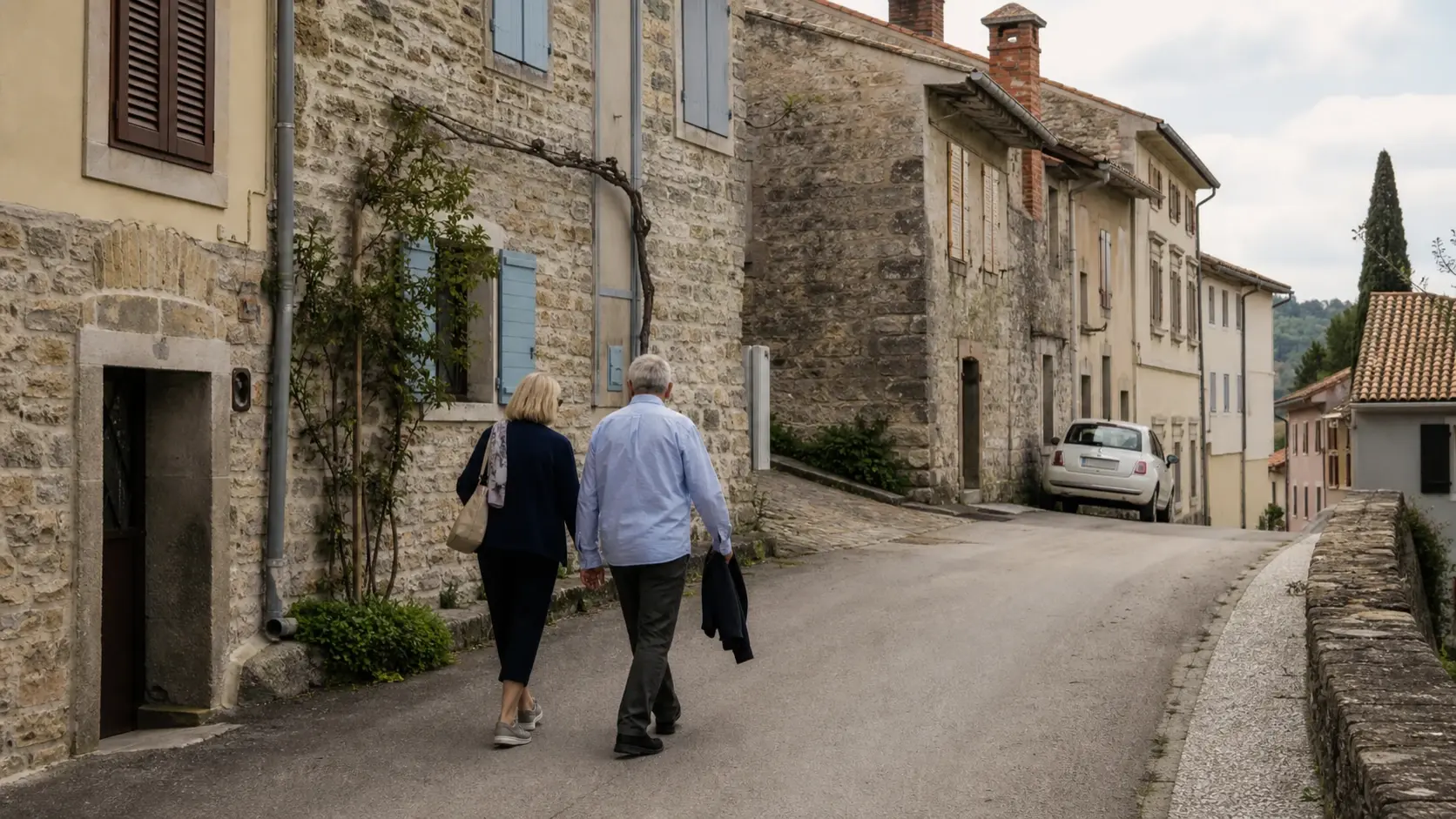 Mature couple walking along a stone street in an Istrian hill town