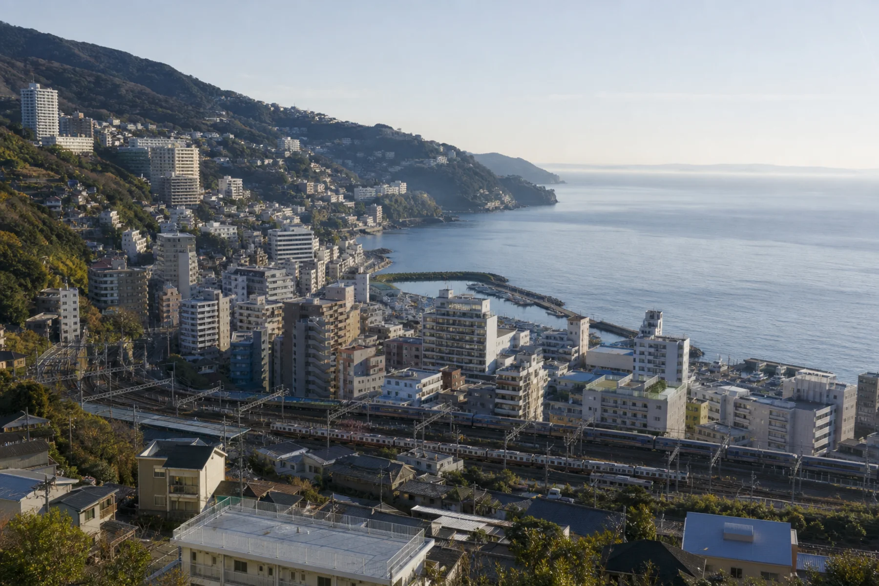 Atami city, railway and steep coast in soft morning light