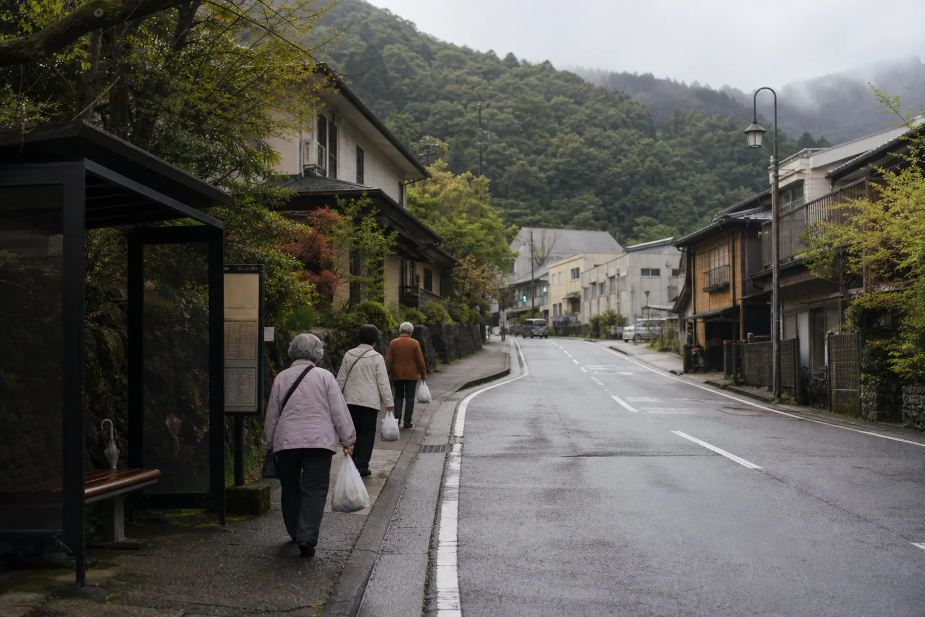 Older residents walking near shops and a bus stop in a Hakone onsen town