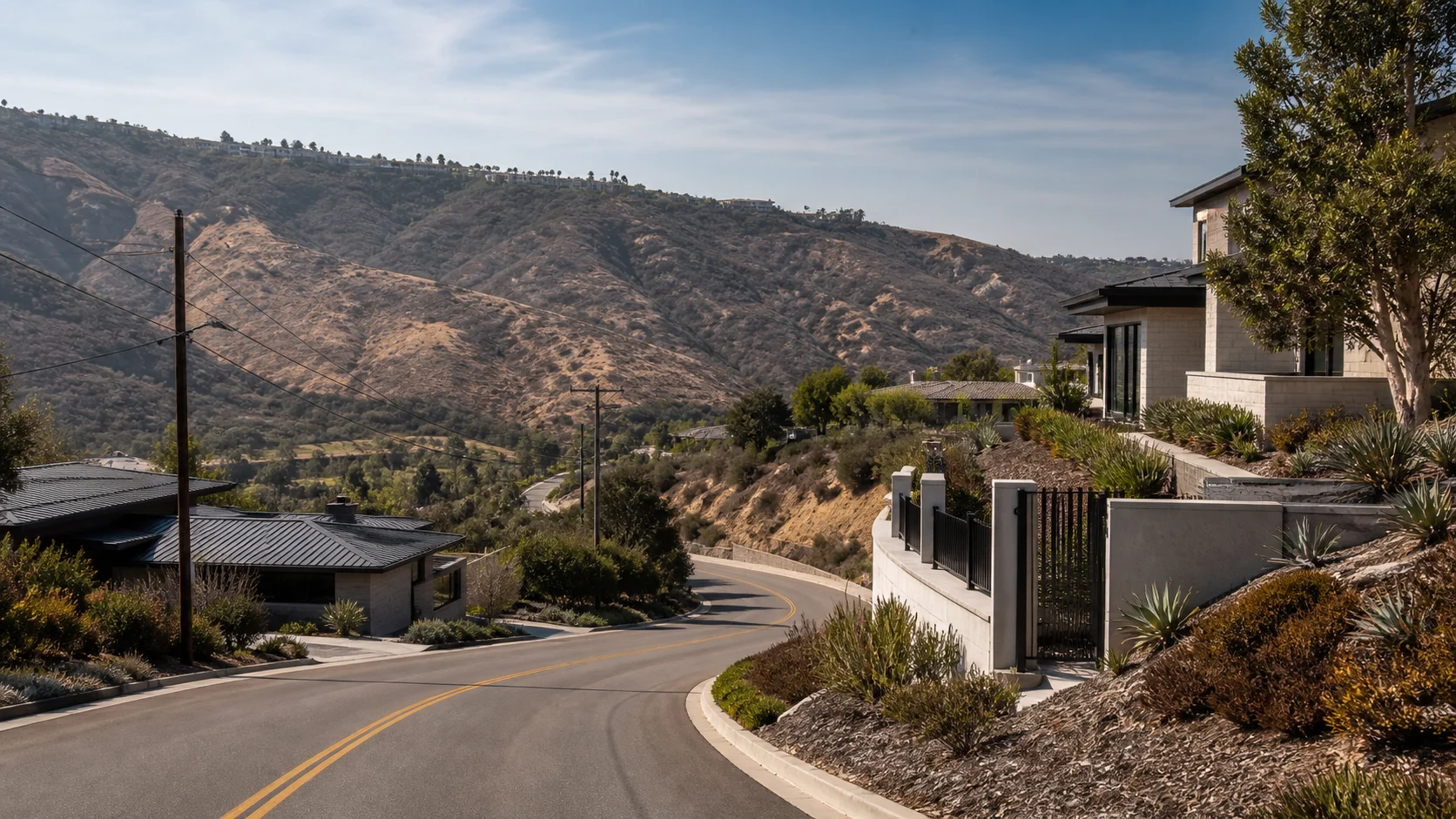 Coastal California hillside homes with defensible landscaping and visible access roads