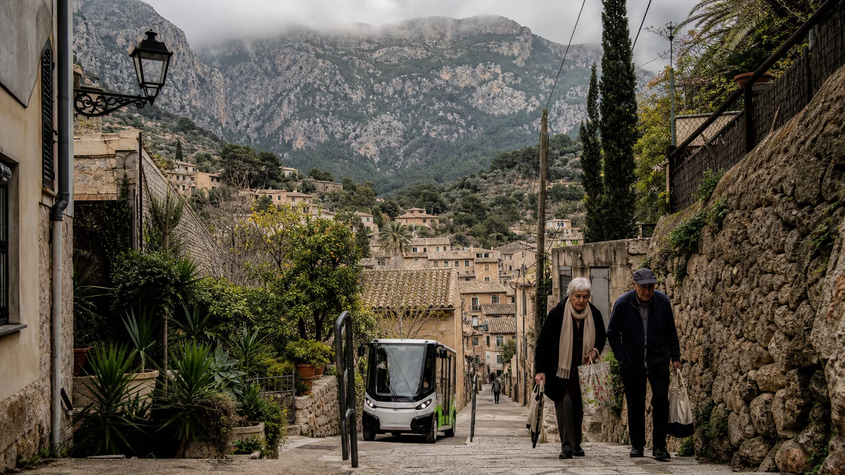 Older residents walking on a steep stone street in Sóller beneath the Tramuntana