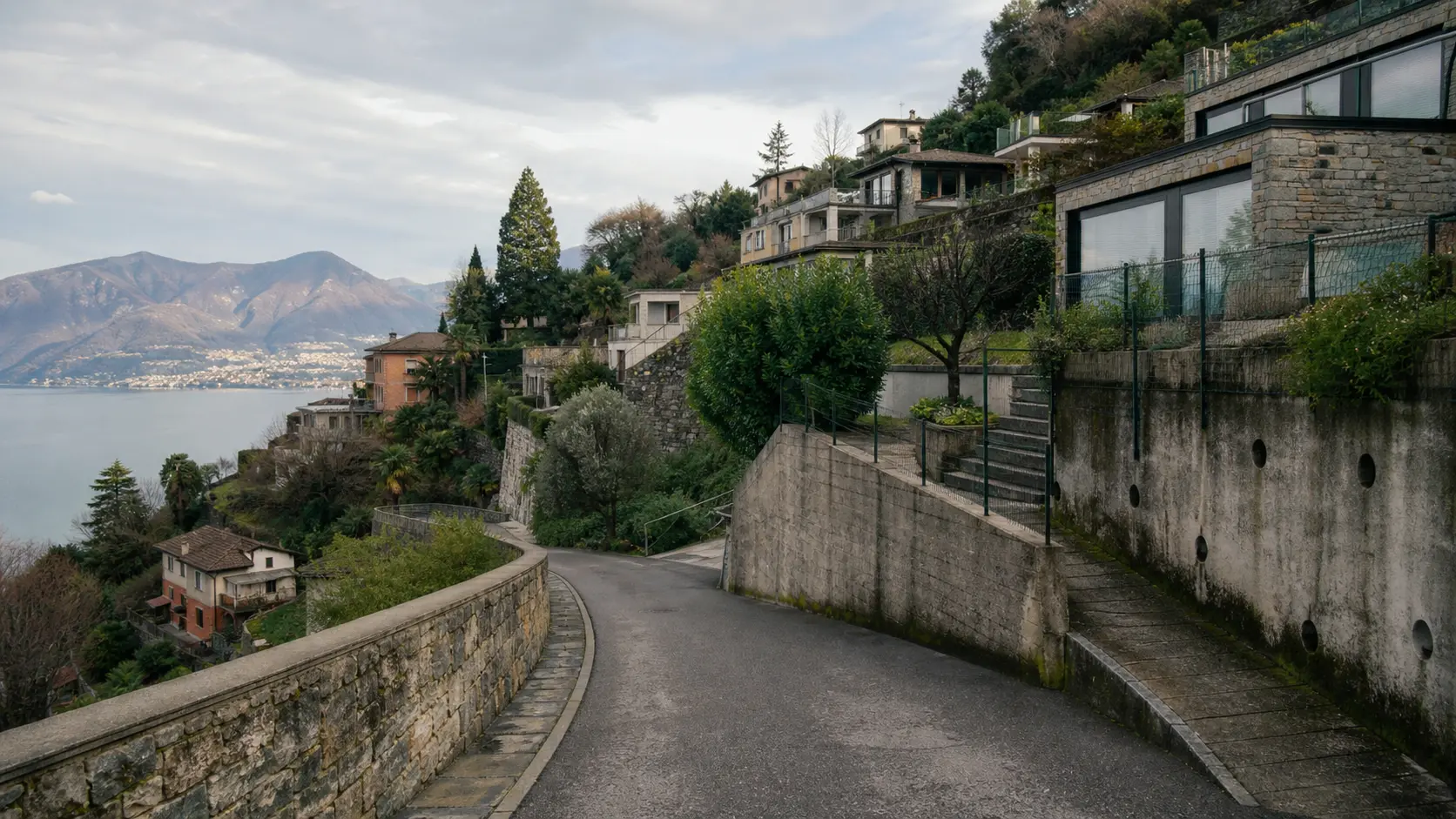 Steep Lake Lugano residential road with retaining walls and hillside homes